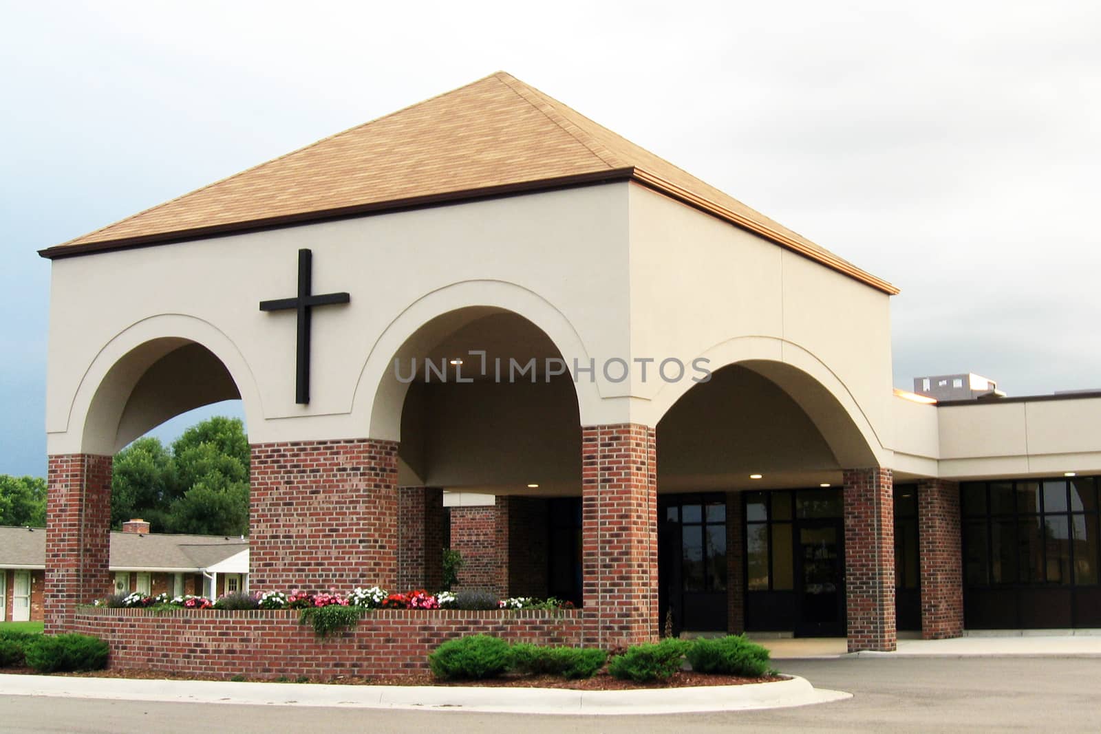 Modern church entrance with a cross on the building.