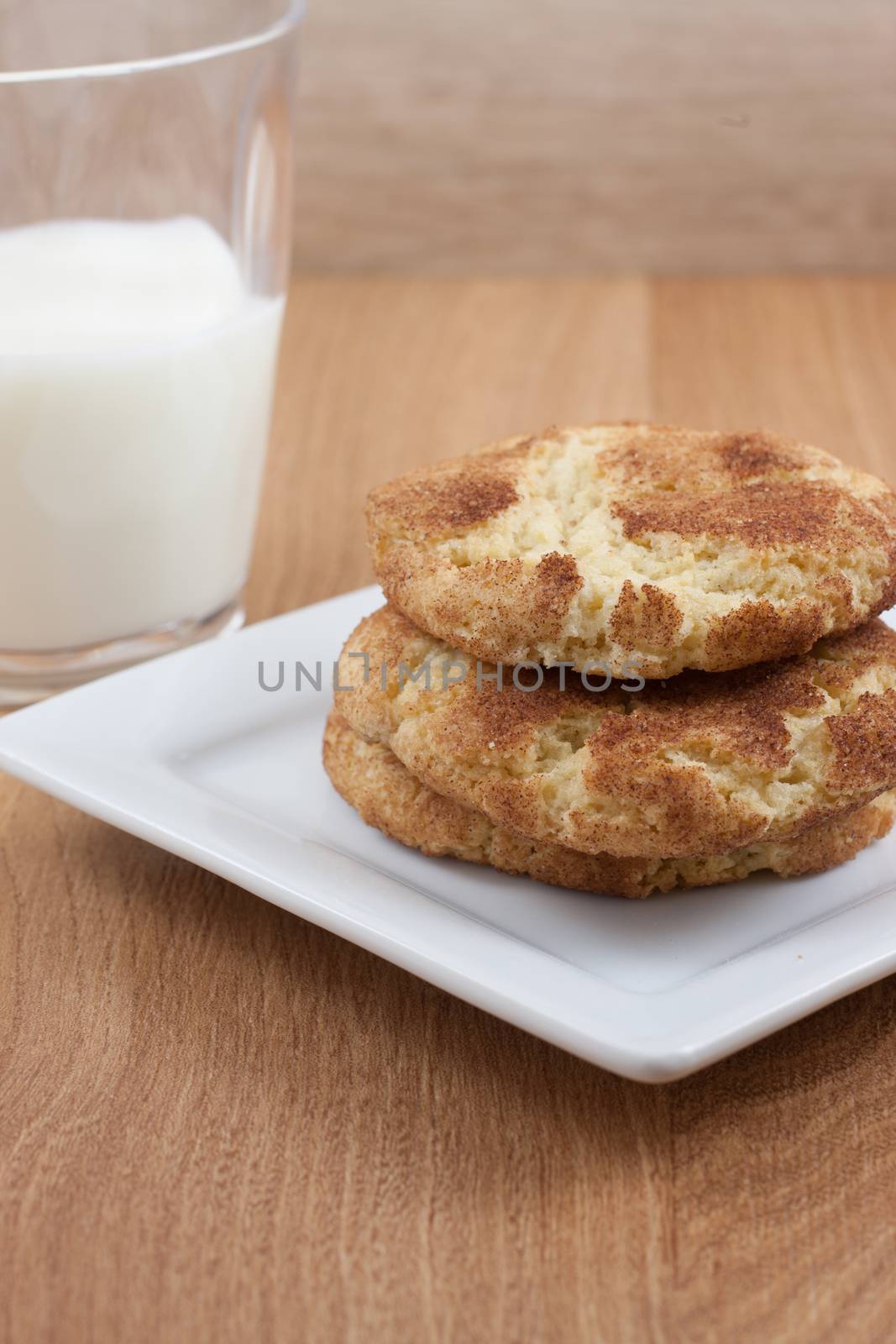 Snicker Doodle cookies  on a white plate and a glass of milk.