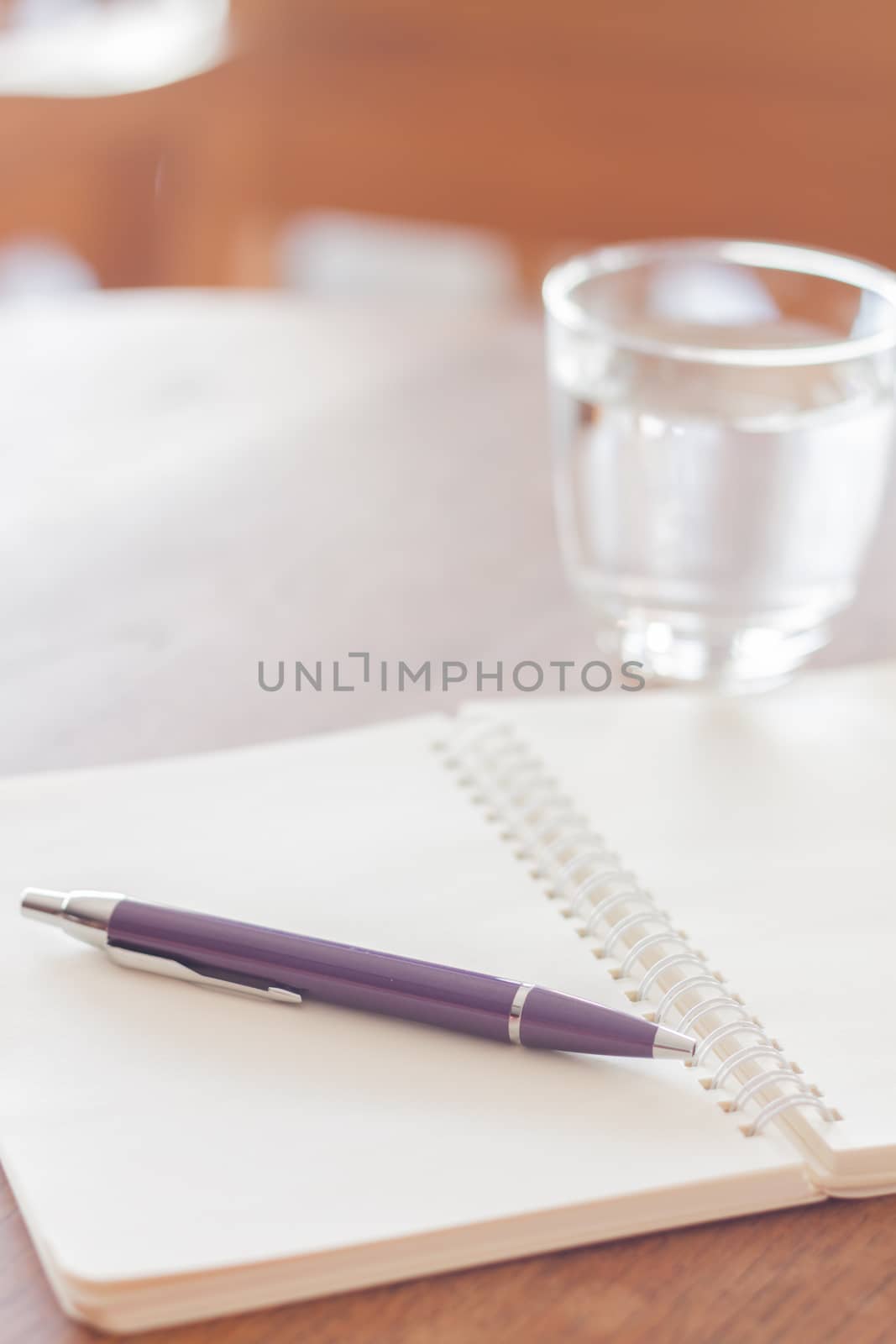 Pen and blank spiral notebook on wooden table, stock photo