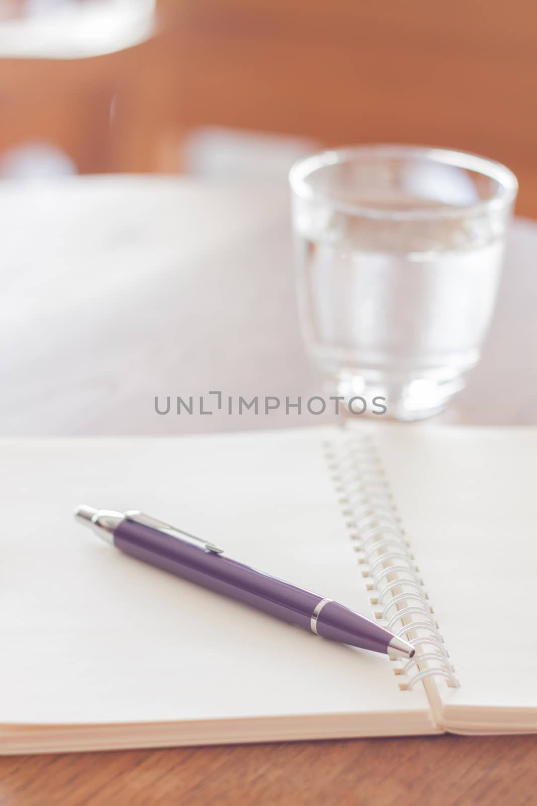 Pen and blank spiral notebook on wooden table, stock photo