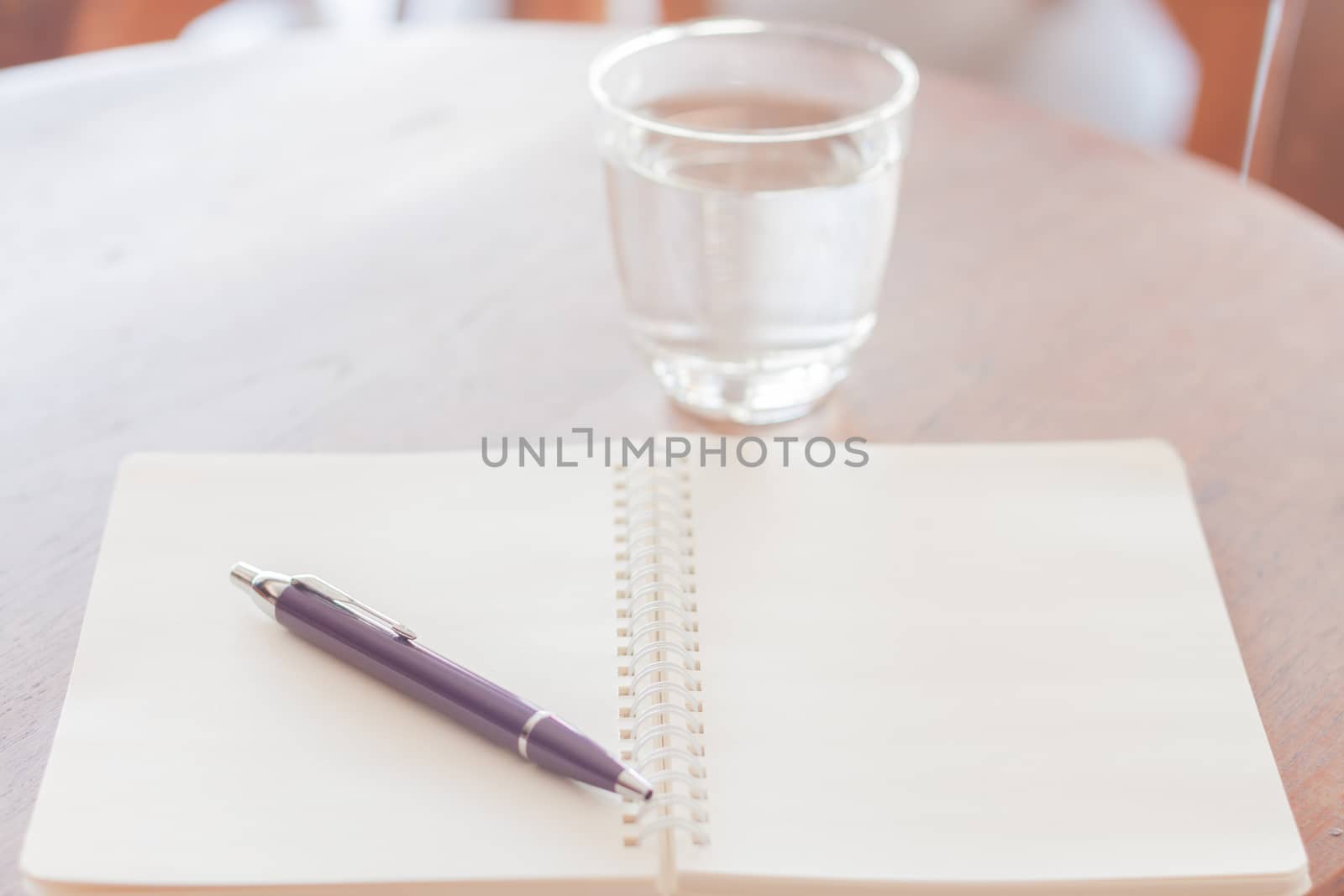 Pen and blank spiral notebook on wooden table, stock photo