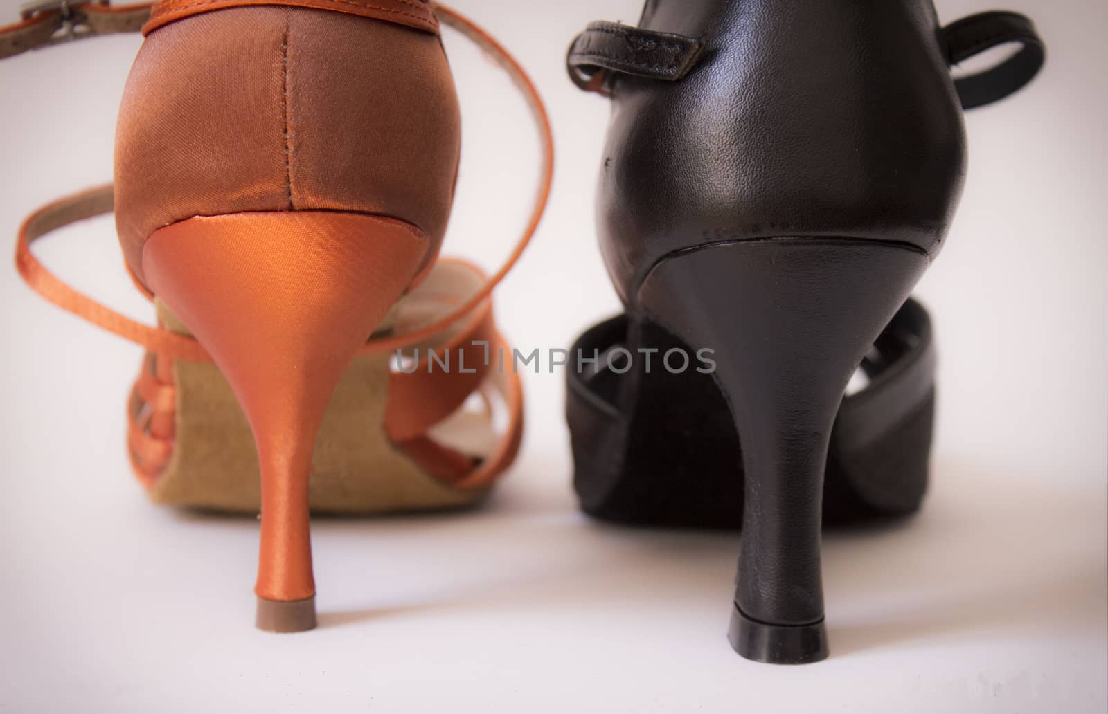 Heeled dancing shoes when viewed from behind. In black and orange.