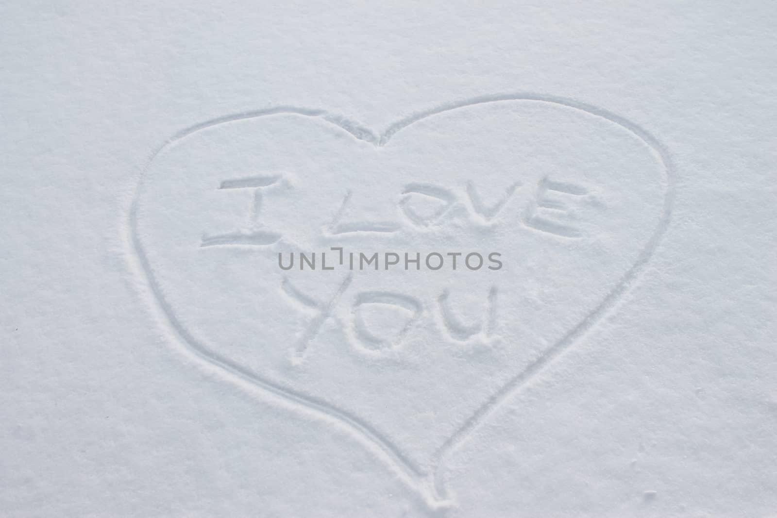 The inscription on the snow, "I love you" inside the heart