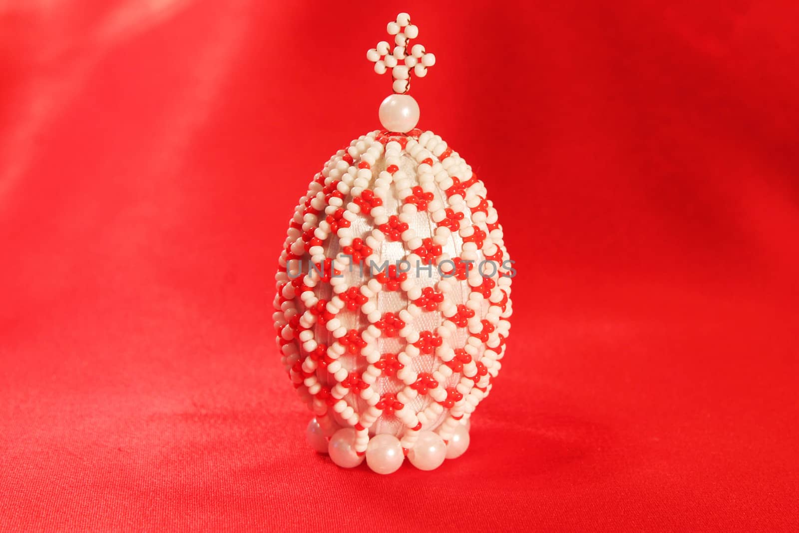 Decorative handmade  beaded  Easter egg placed on red silk