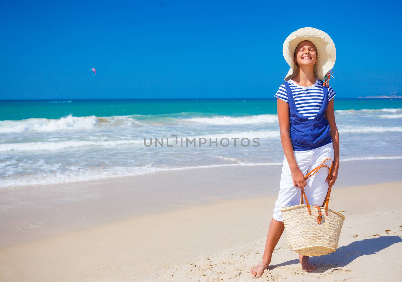 Summer vacation, lovely girl walking on the beach near water