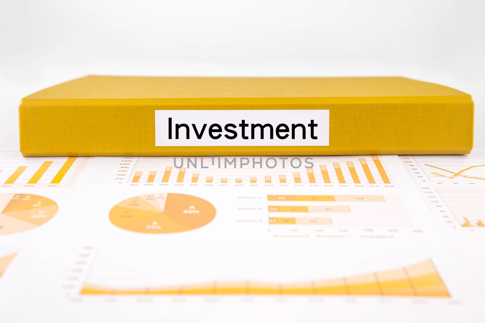 Yellow document binder with investment word place on income summary, graph analysis and financial report for budget plan