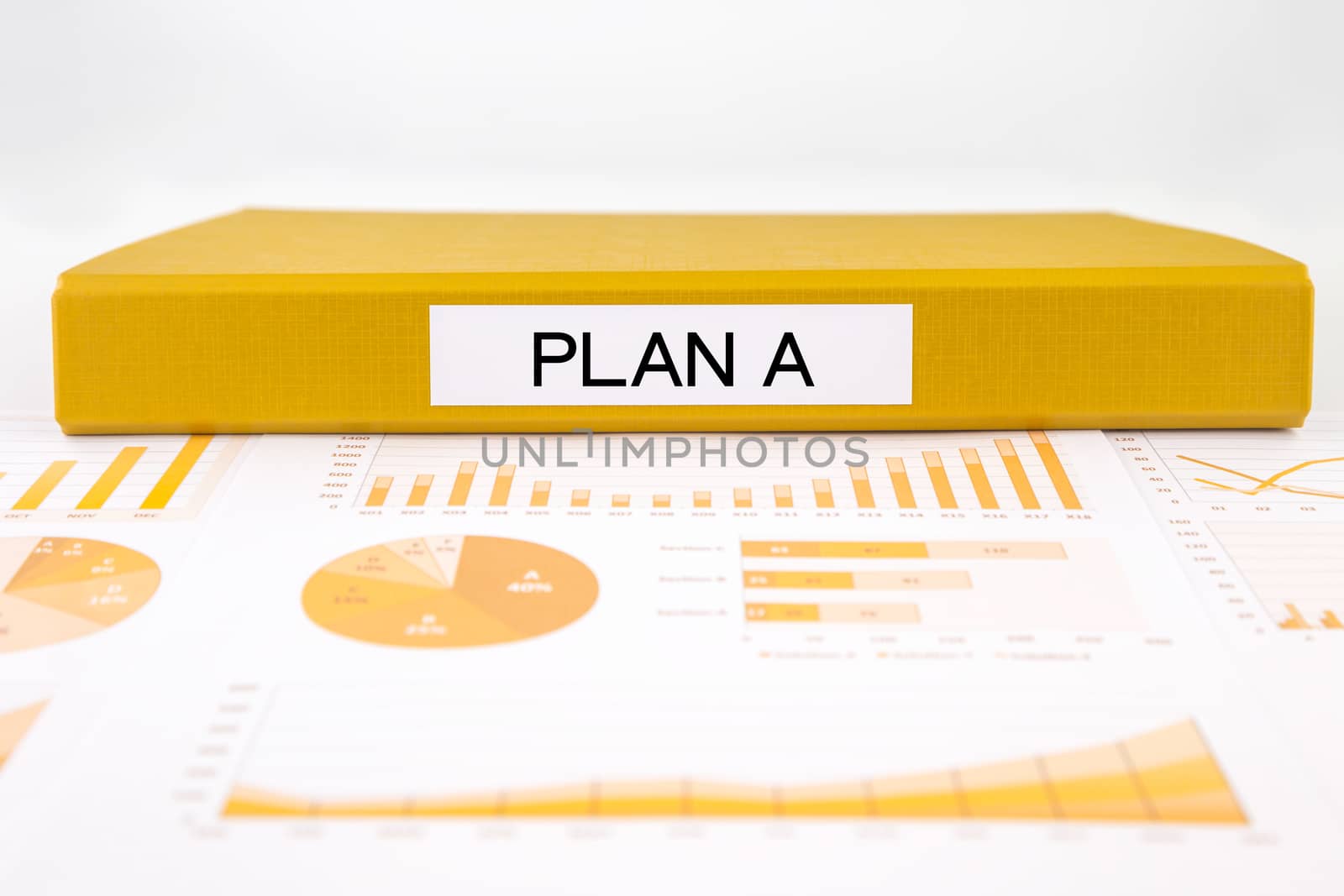 Yellow document binder with PLAN A word place on graphs and charts of business plan, solution for project management