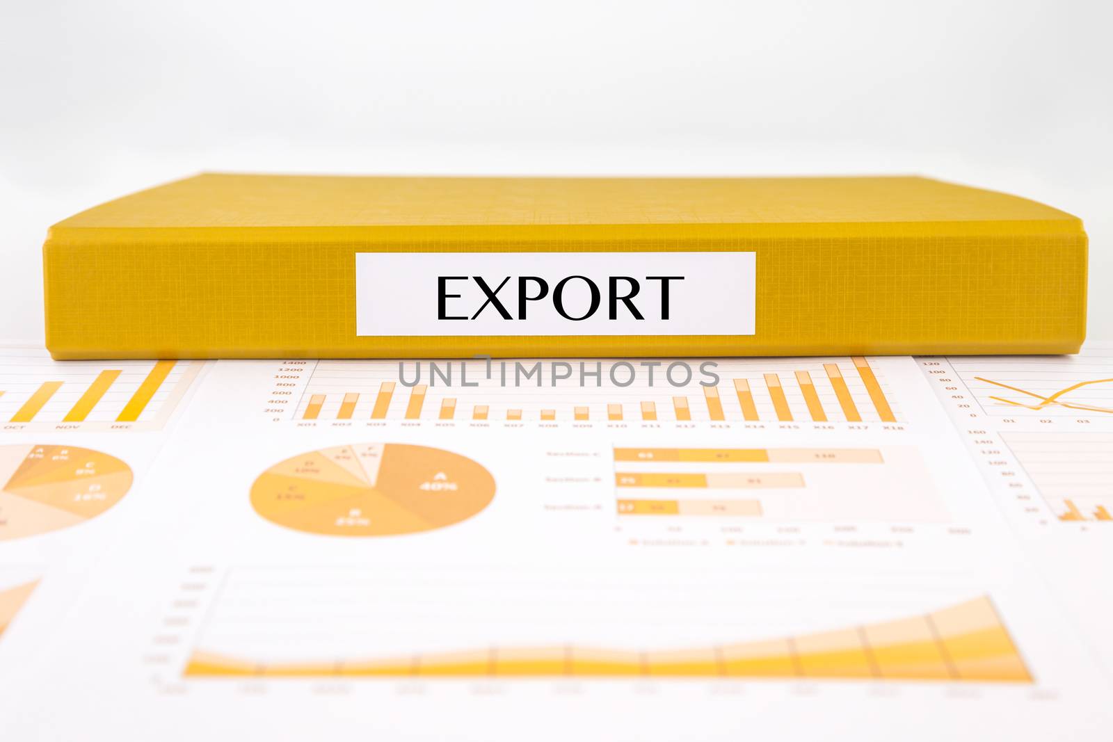 Yellow document binder with EXPORT word place on graph analysis, market and sales reports