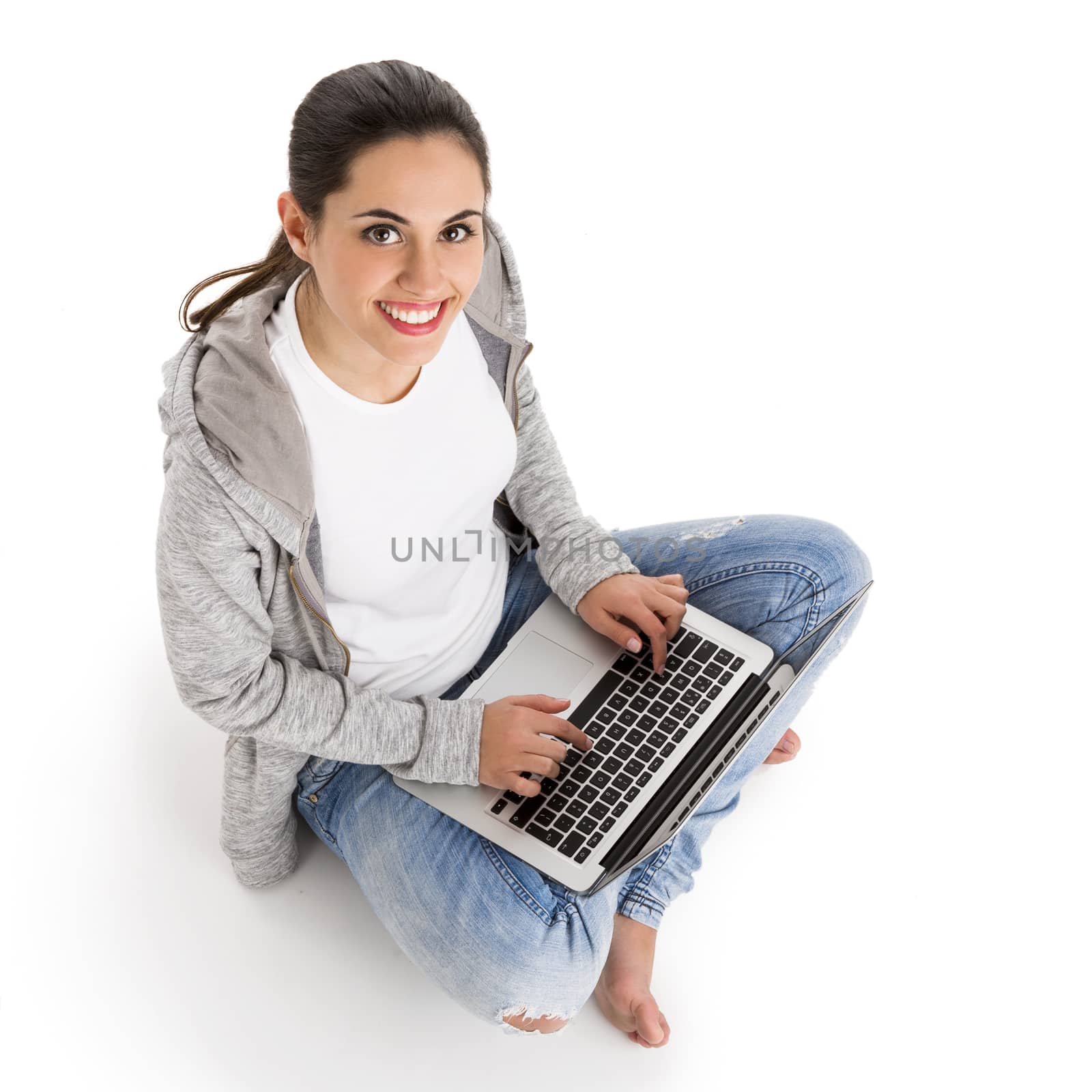 Beautiful woman sitting with crossed legs working with a laptop