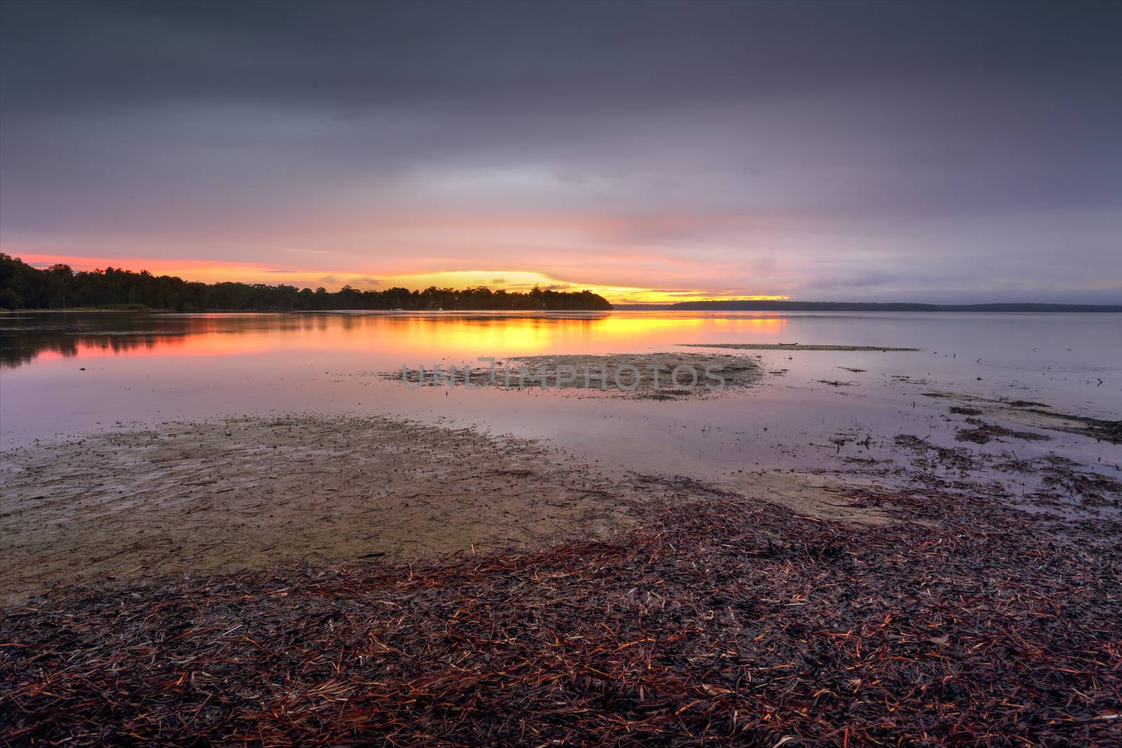 Clouds closed in the skies in the late afternoon.  Standing in rain with my dog to capture the only colour to the south west and a blush of colour on the clouds and reflections in the pristine waters of St Georges Basin Sanctuary Point.
