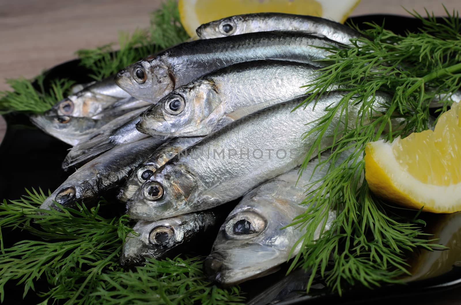 A pile of salted sprats in a bowl on the table