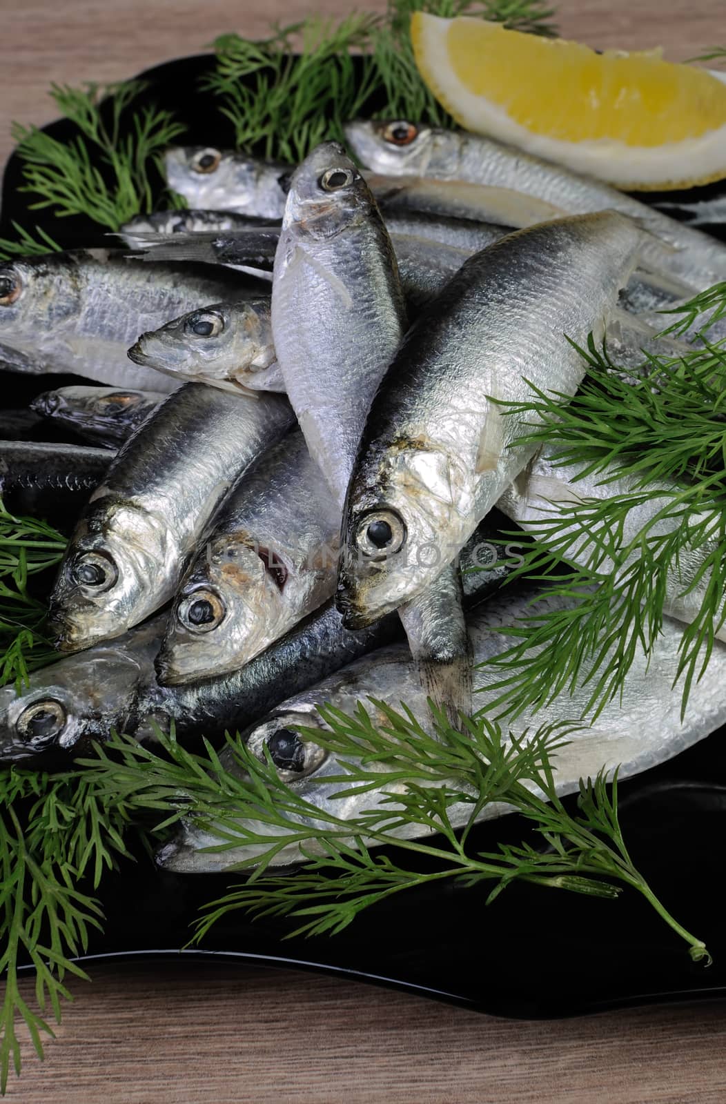 A pile of salted sprats in a bowl on the table