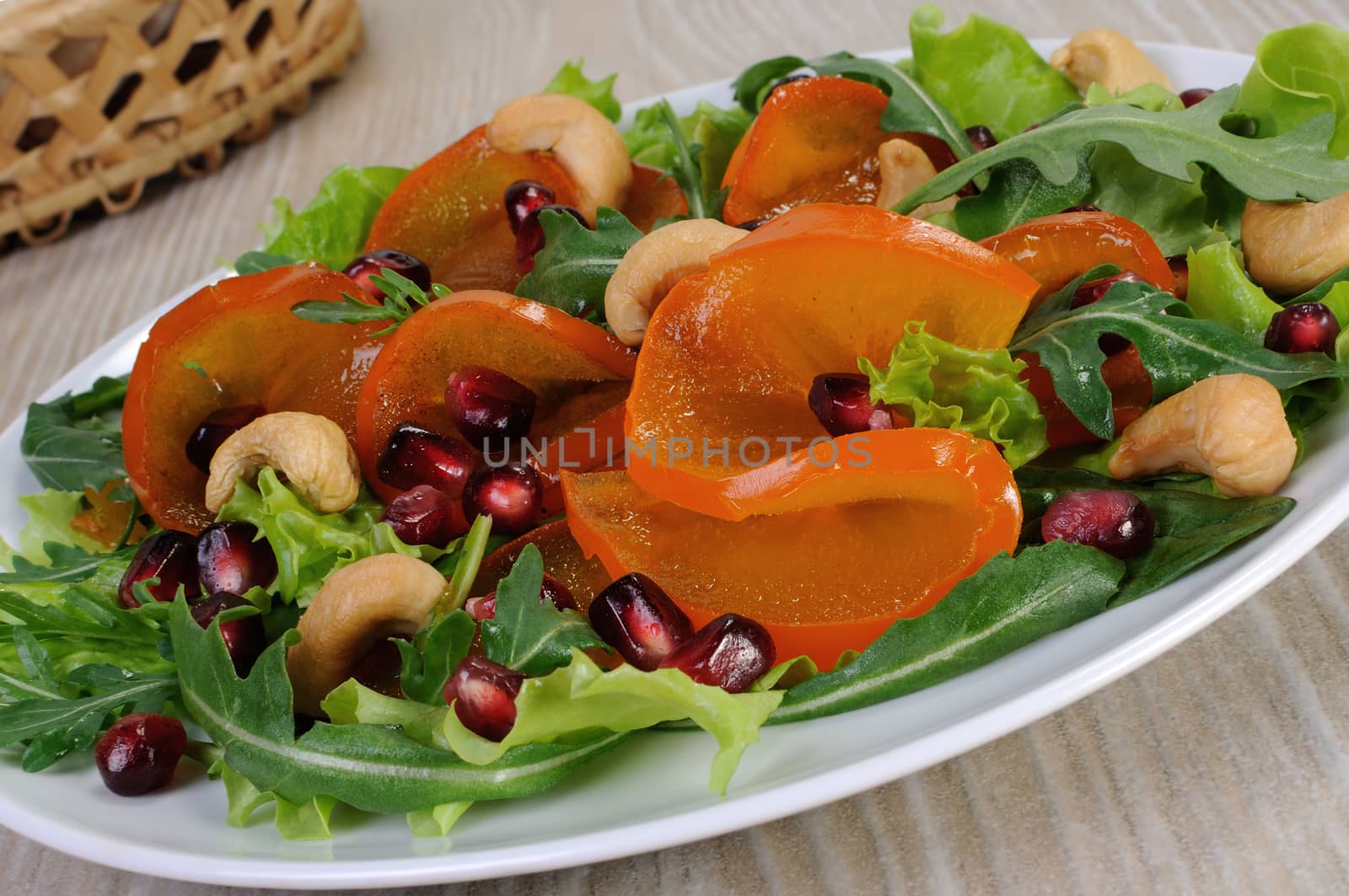 salad of spinach, arugula, lettuce, persimmon, pomegranate and cashews
