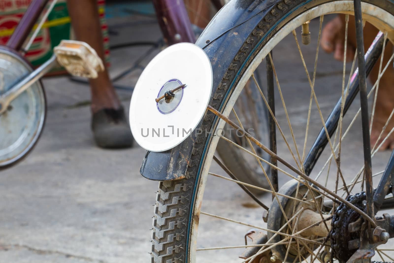 cd disc on rear mudguard of bicycle, used as reflector, thailand