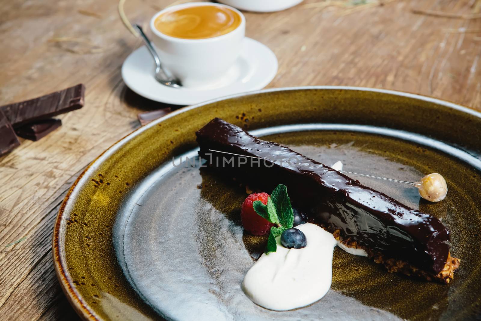 Piece of chocolate cake with  fresh berry on wooden background