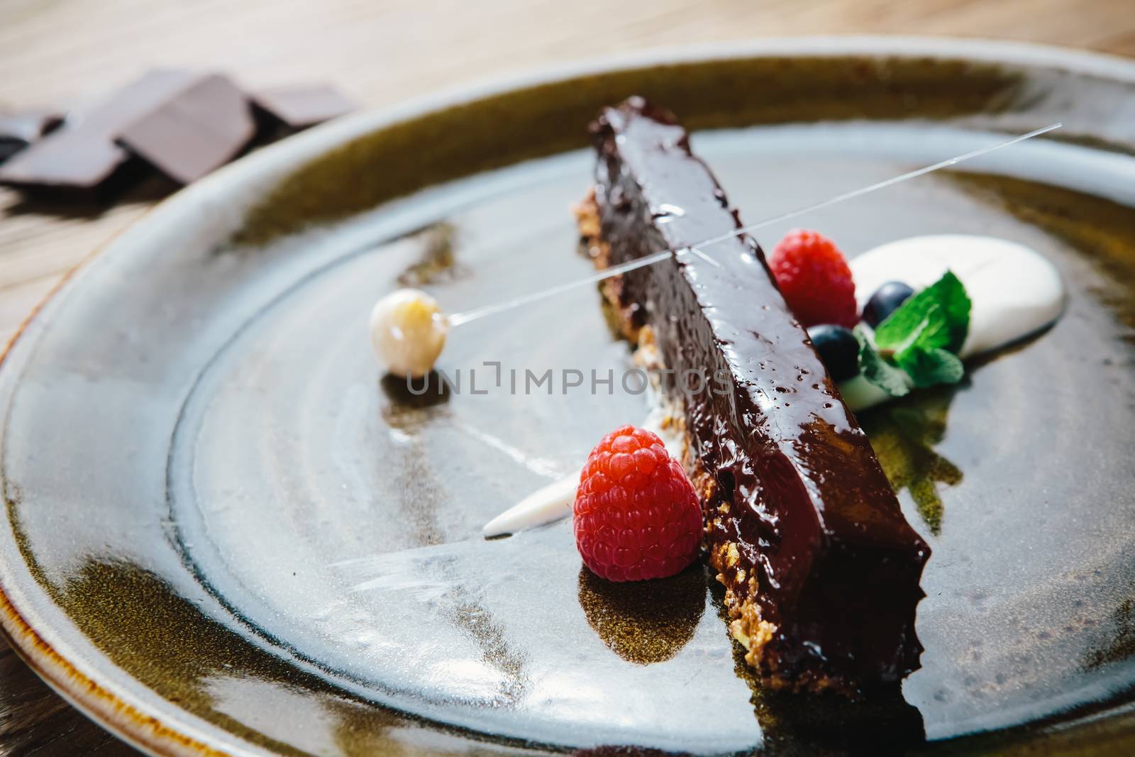 Piece of chocolate cake with  fresh berry on wooden background