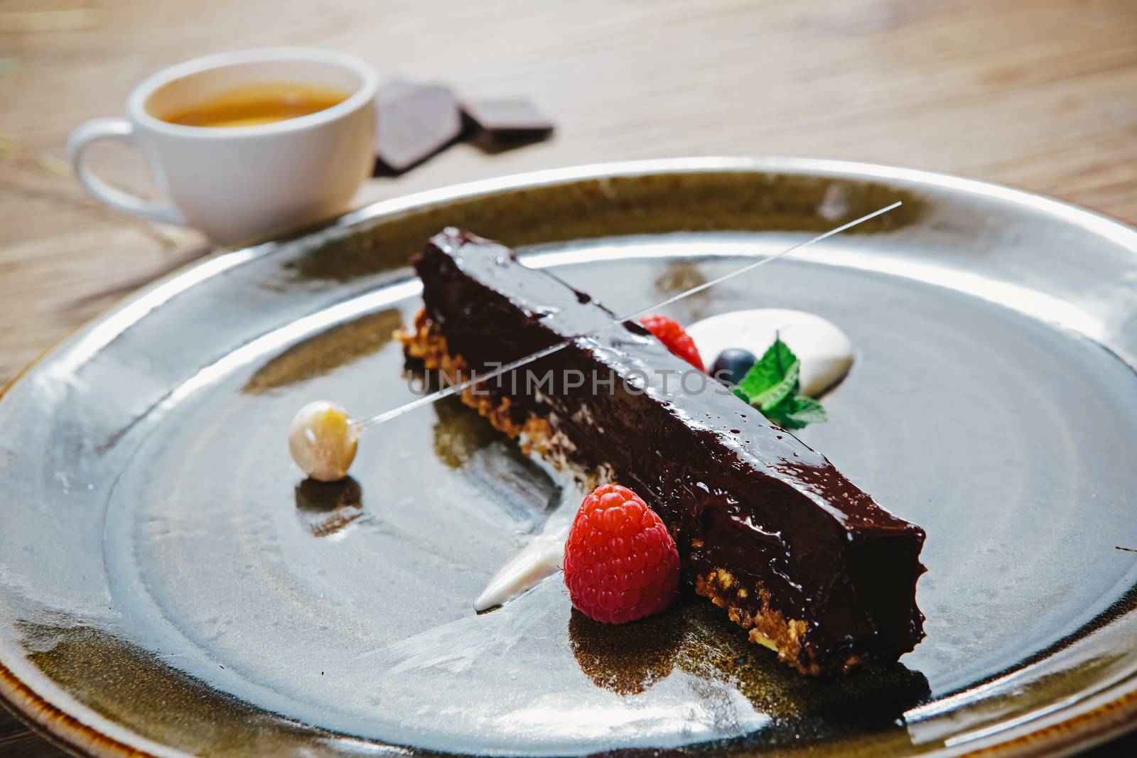 Piece of chocolate cake with  fresh berry on wooden background