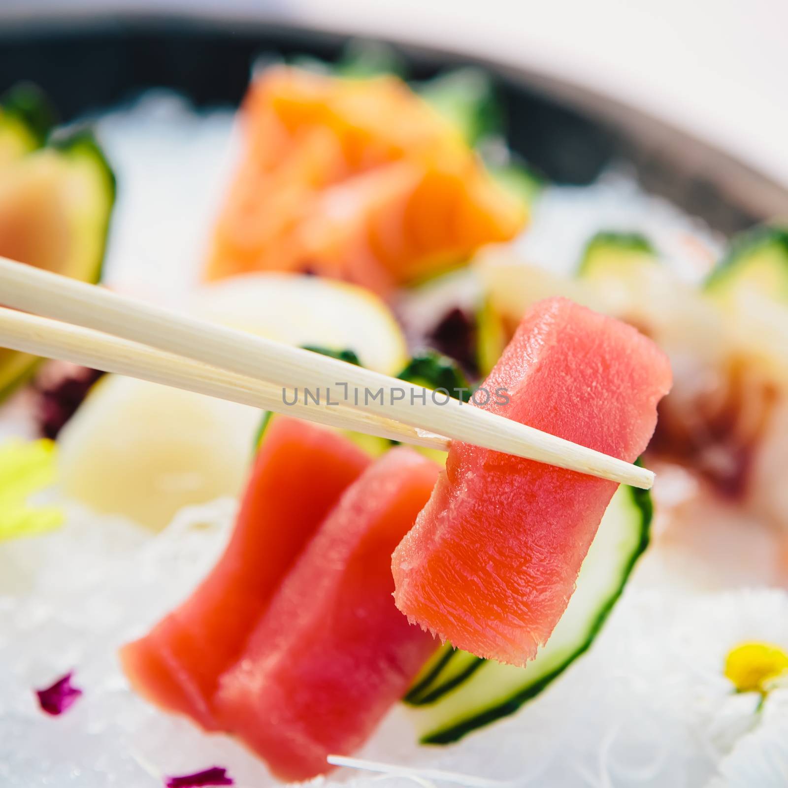 Tuna Sashimi - Maguro fresh raw tuna on Daikon White Radish. Garnished with Ginger, Wasabi, Seaweed, Cucumber, Salad Leaf and Lemon