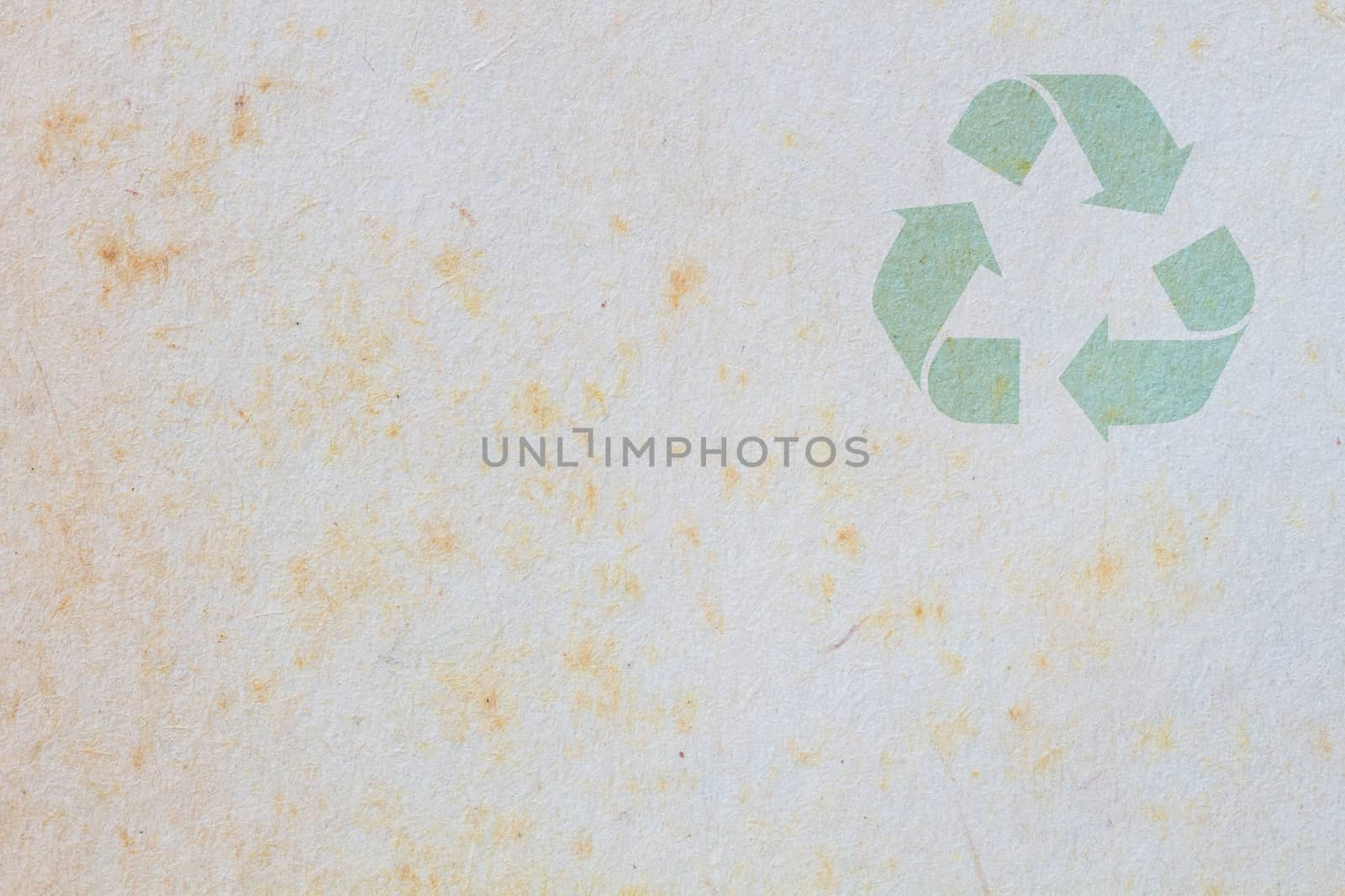 texture of old paper with yellow stain, background, with symbol of recycle on the upper corner