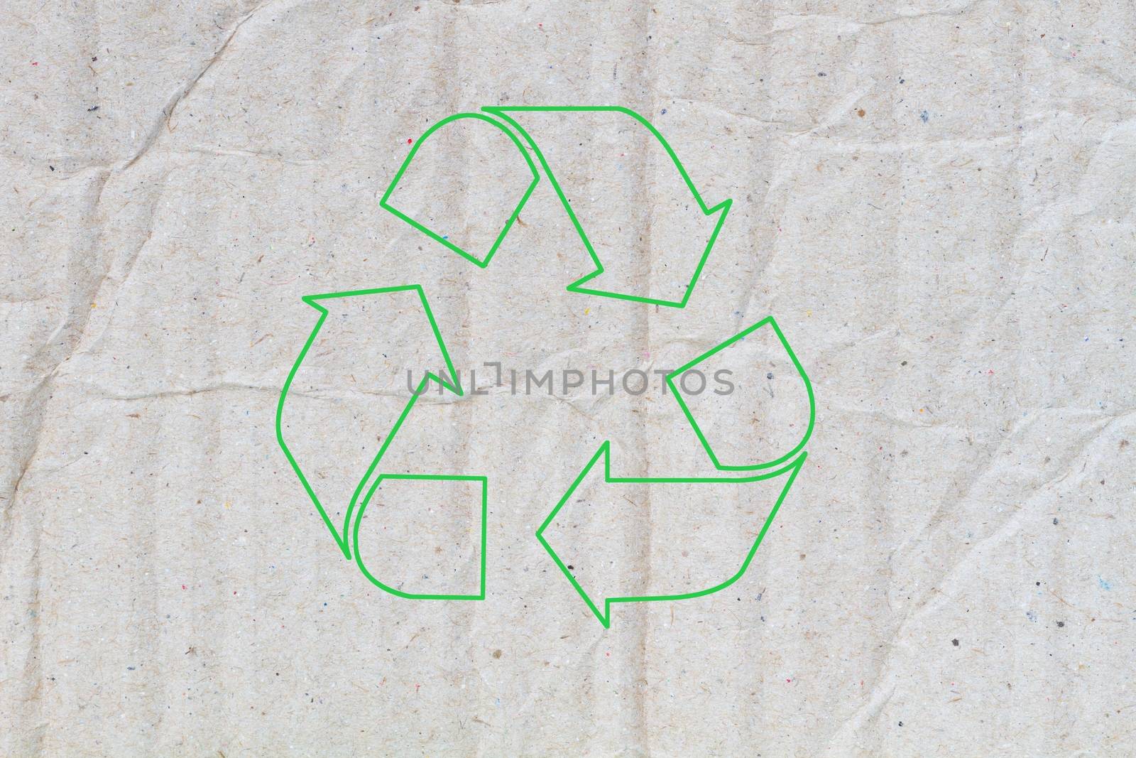 background of crumpled grey cardboard with texture, with green sign of recycle
