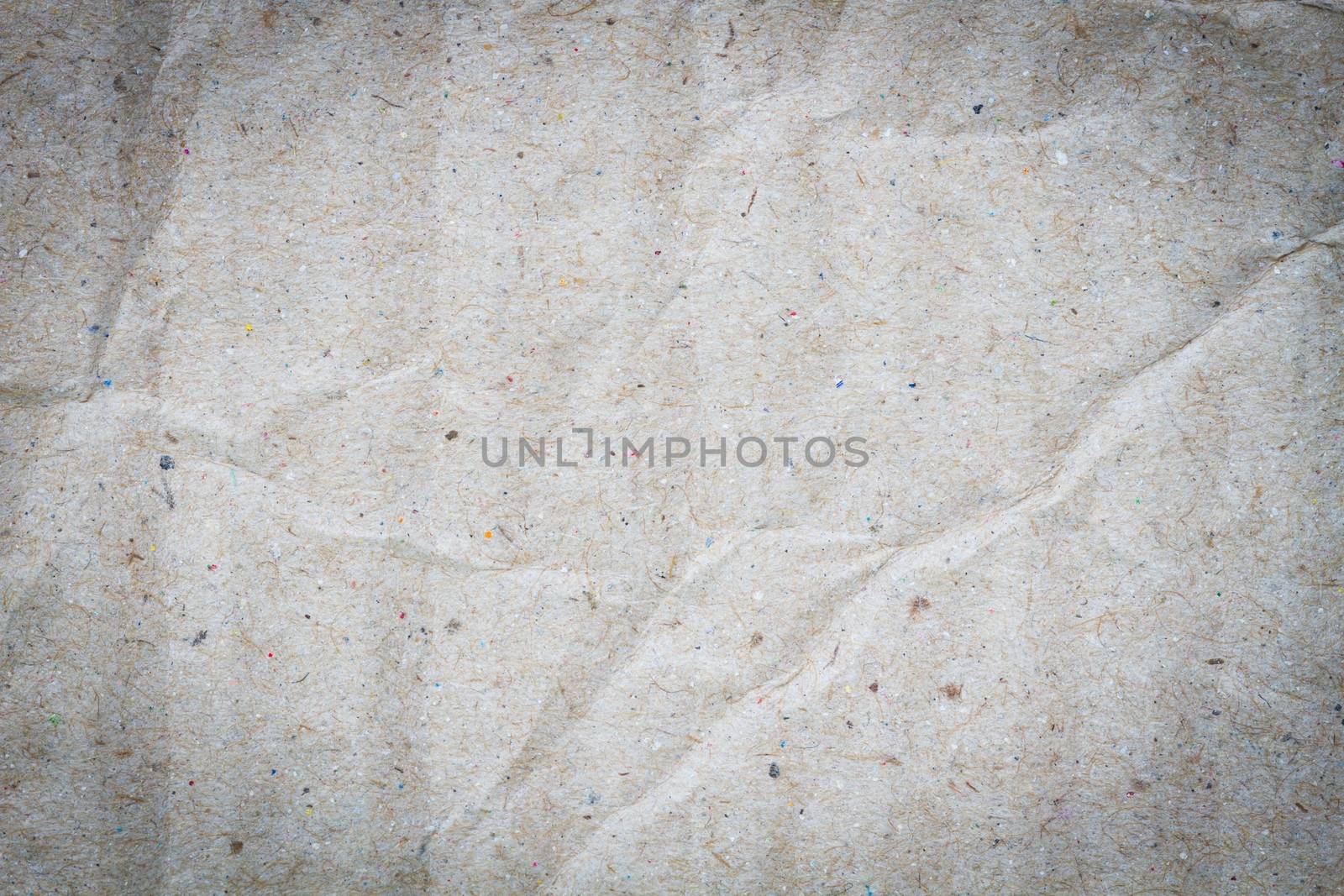 macro of crumpled grey cardboard paper as background with texture, vignette