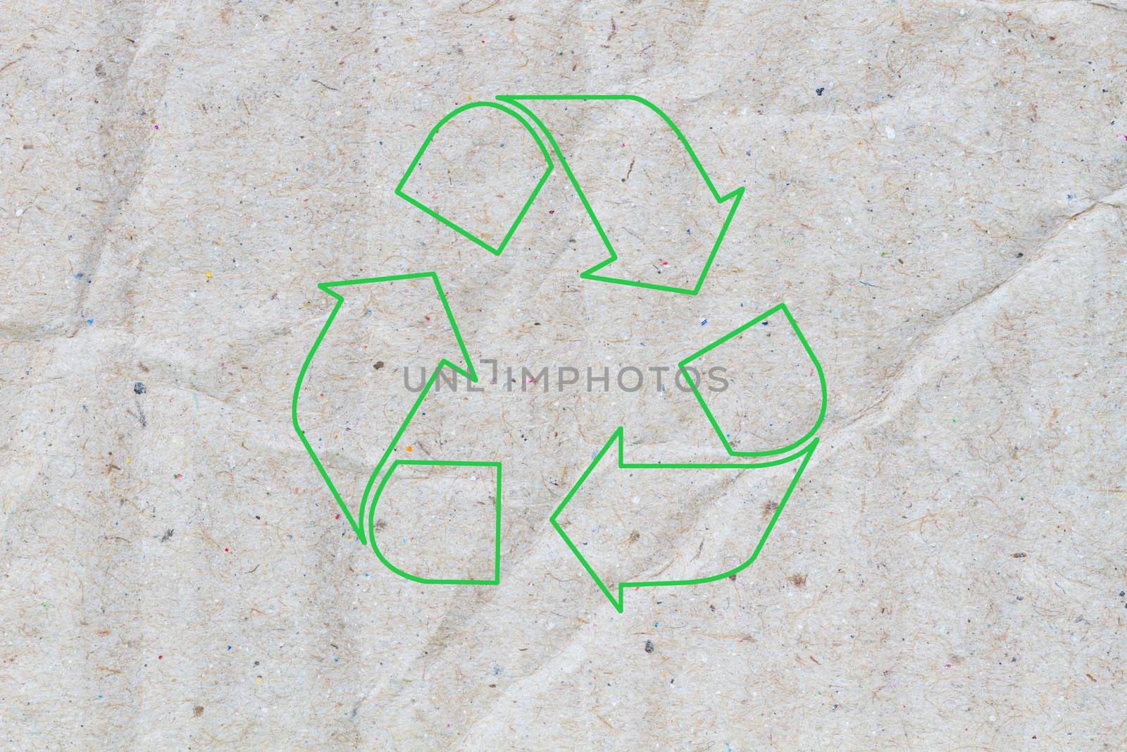 macro of crumpled grey cardboard paper as background with texture, with green sign of recycle