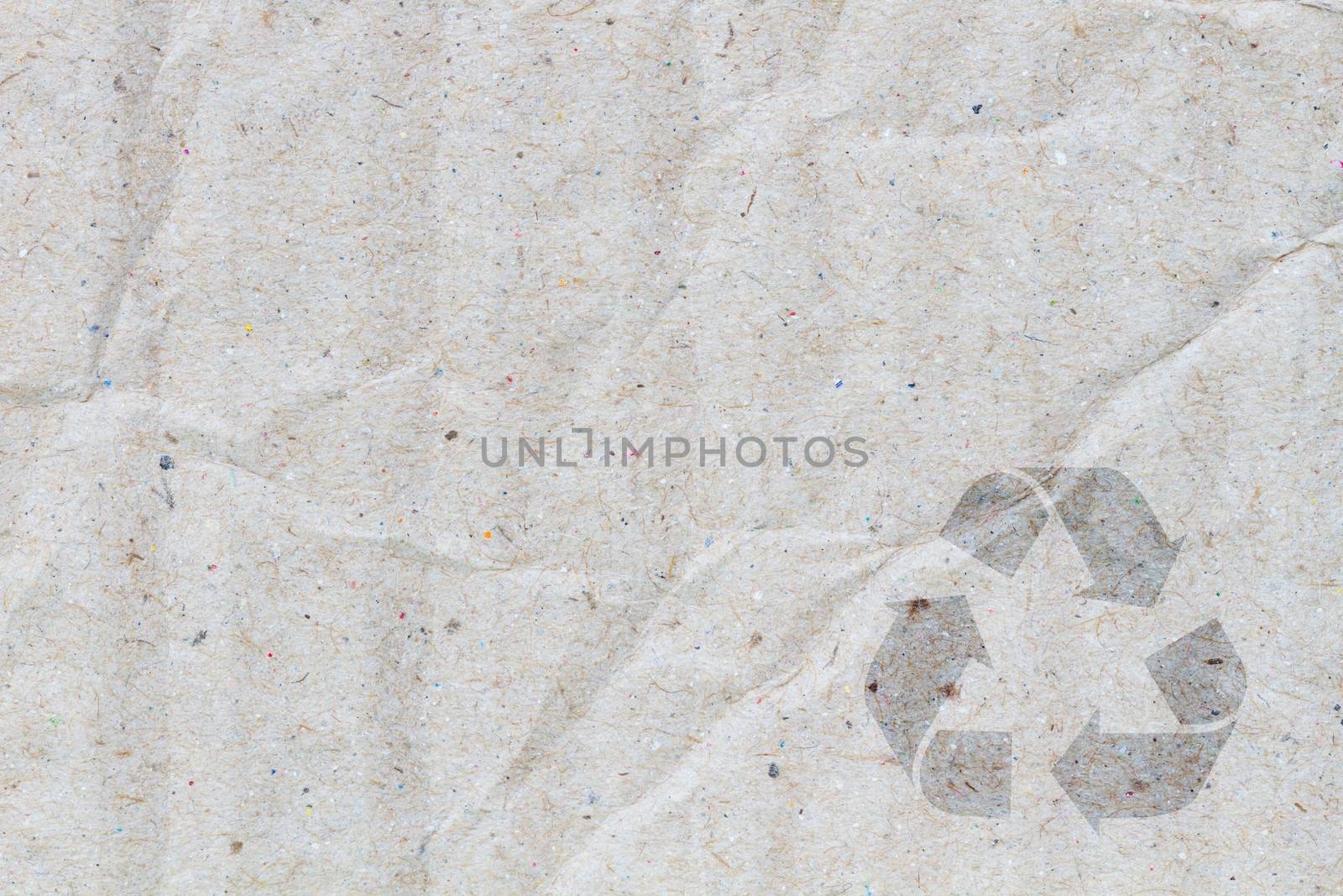 macro of crumpled grey cardboard paper as background with texture, with symbol of recycle on the below corner