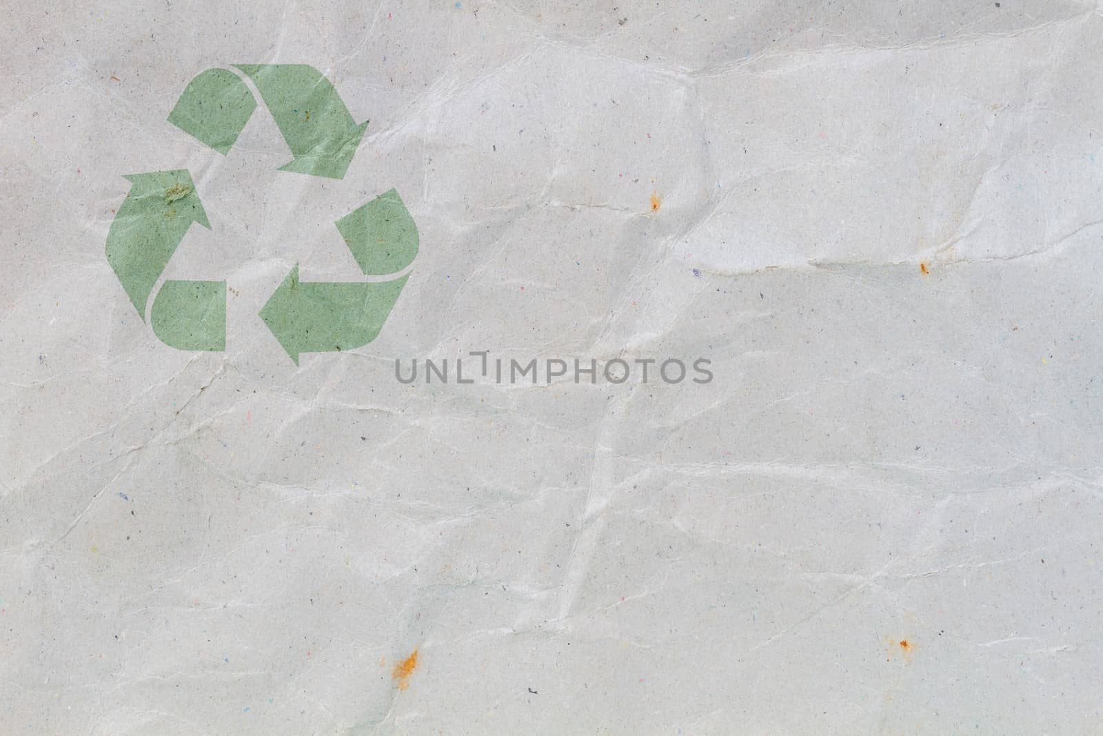 crumpled grey cardboard with background and texture, with symbol of recycle on the upper corner