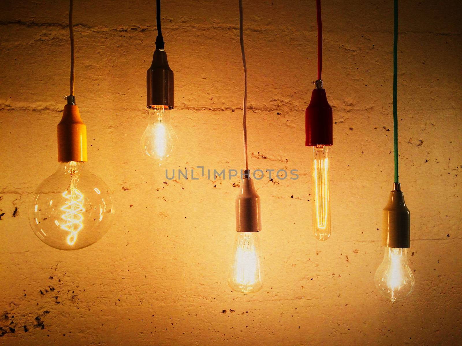 Light bulbs decorating a concrete wall by anikasalsera