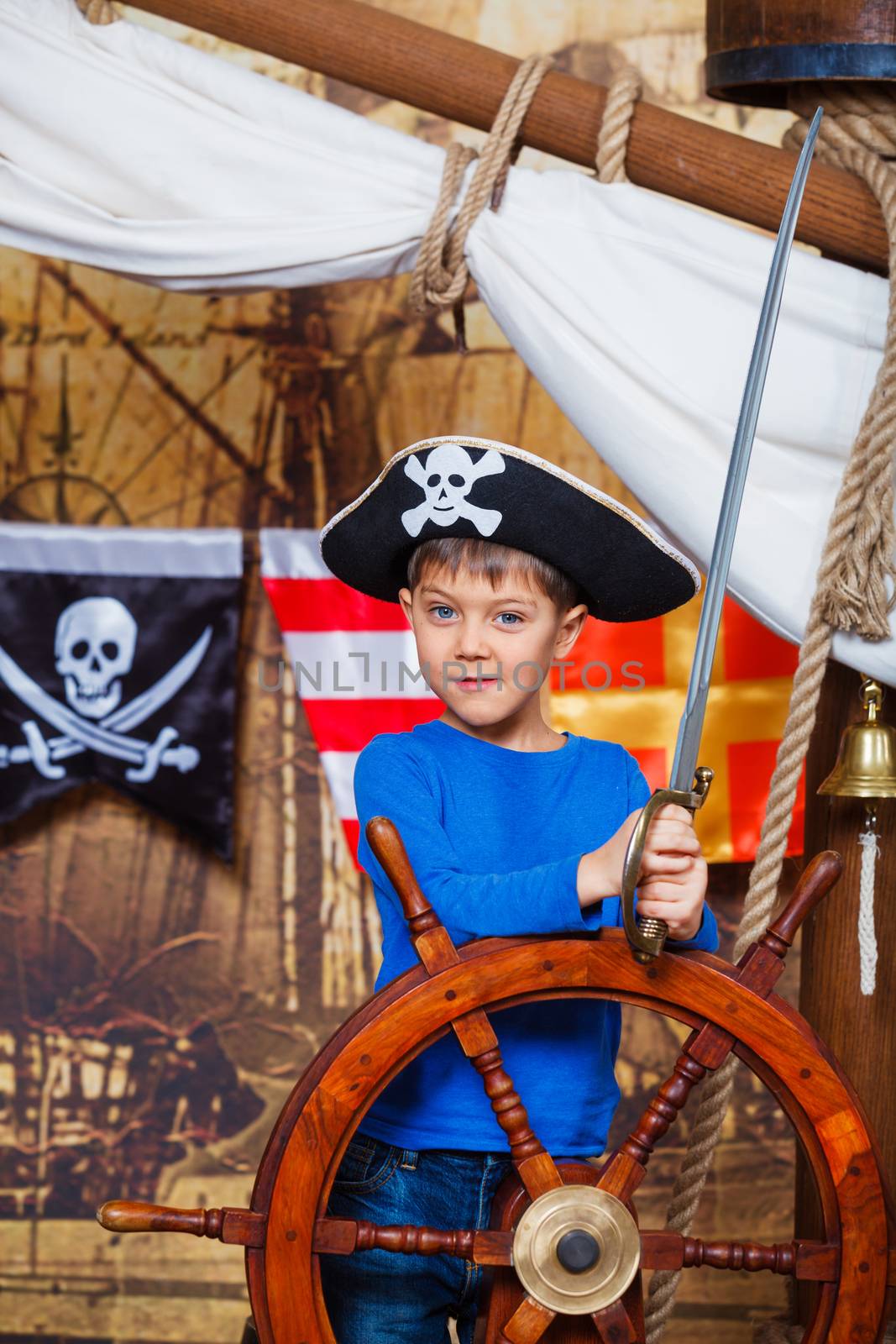 Cute little boy wearing pirate costume on the deck of a ship