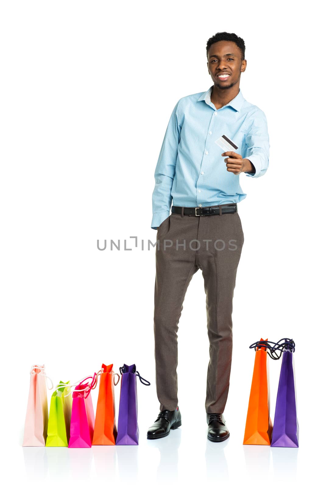 Happy african american man with shopping bags and holding credit card on white background. Holidays concept