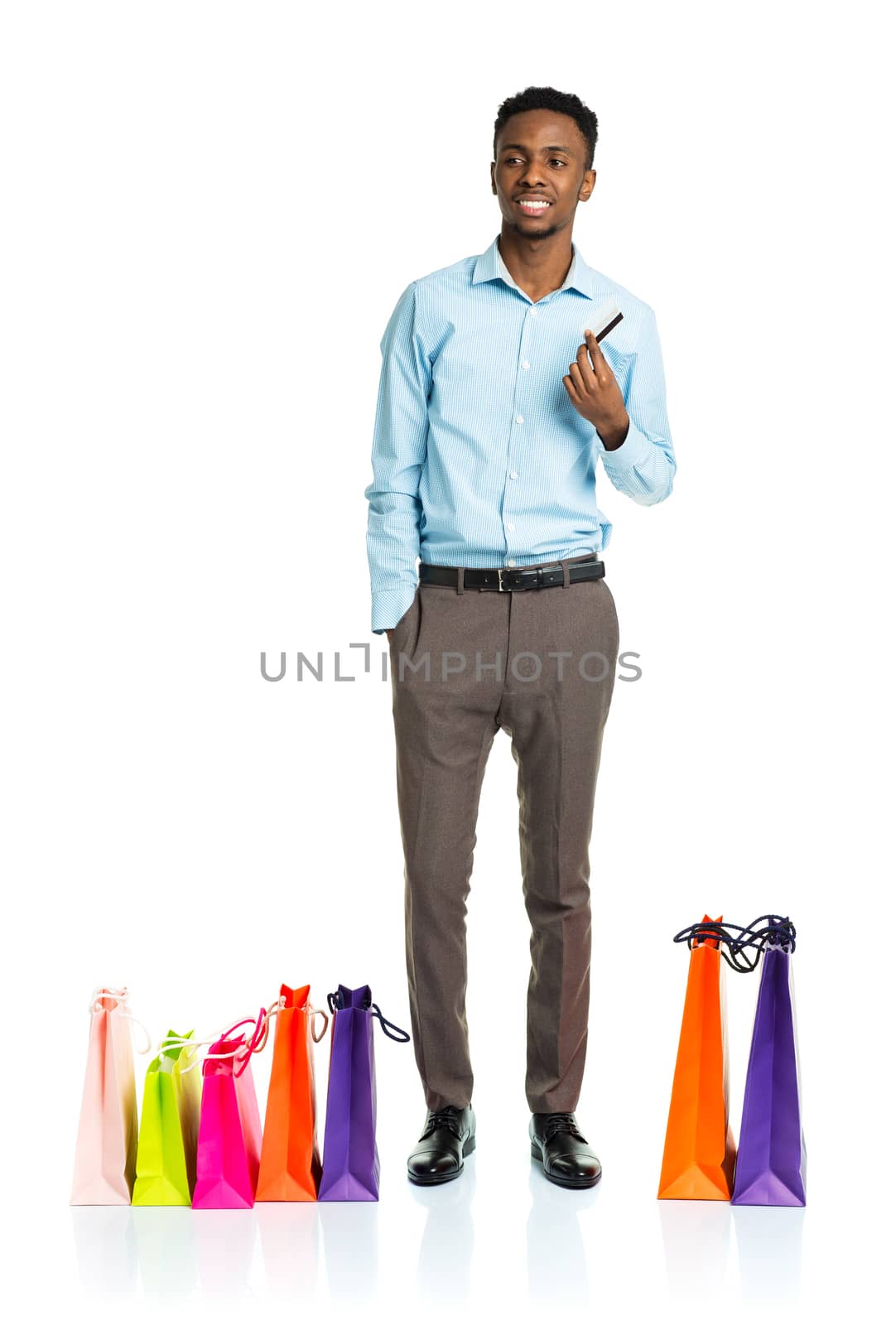 Happy african american man with shopping bags and holding credit card on white background. Holidays concept