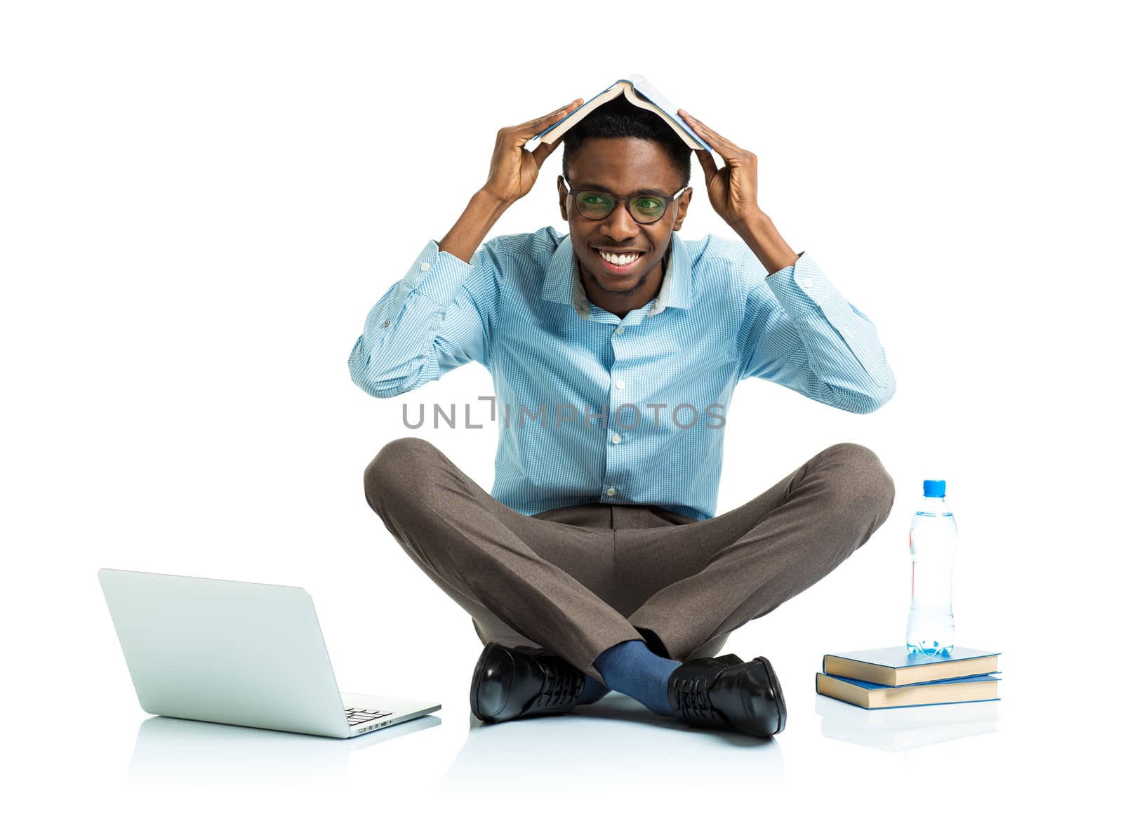 Happy african american college student with laptop, books and bottle of water sitting on white background