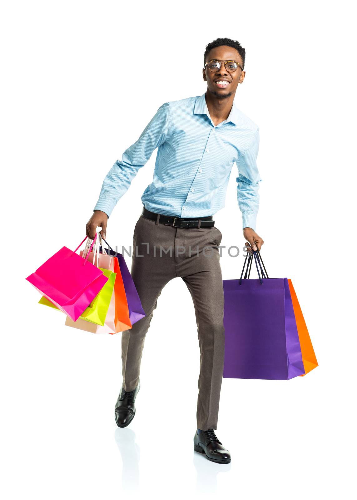 Happy african american man holding shopping bags on white background. Holidays concept