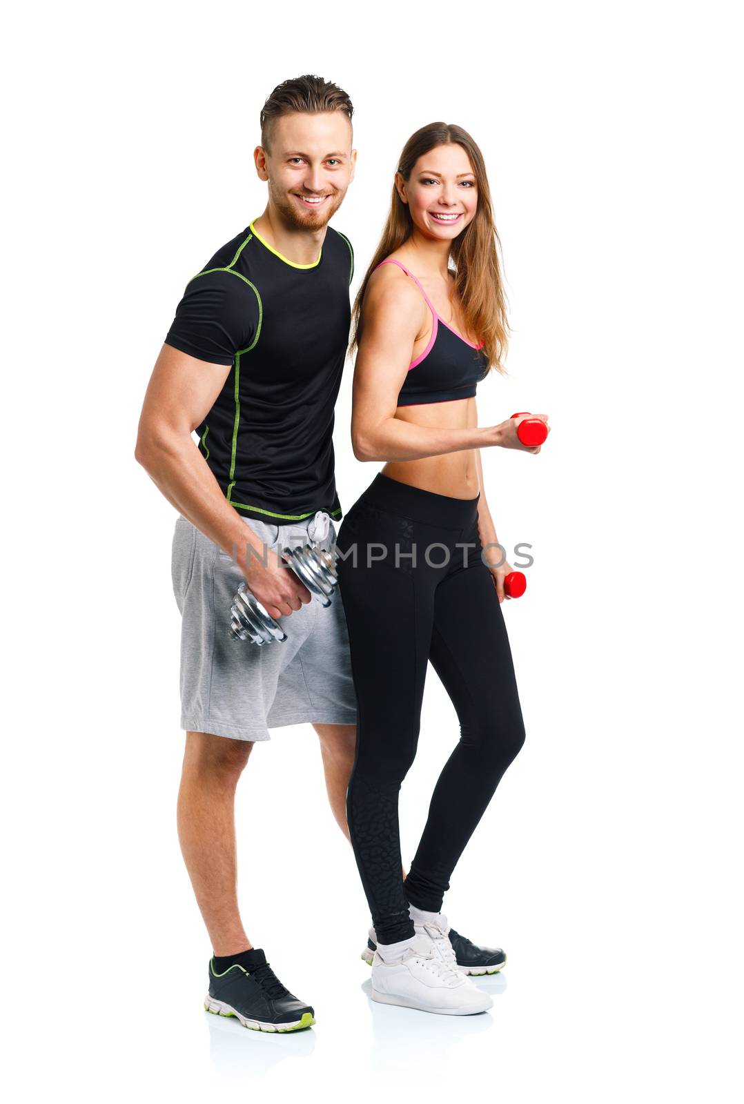 Sport couple - man and woman with dumbbells on the white background