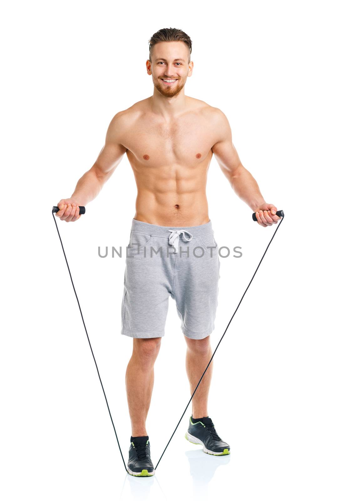 Athletic attractive man jumping on a rope on the white background