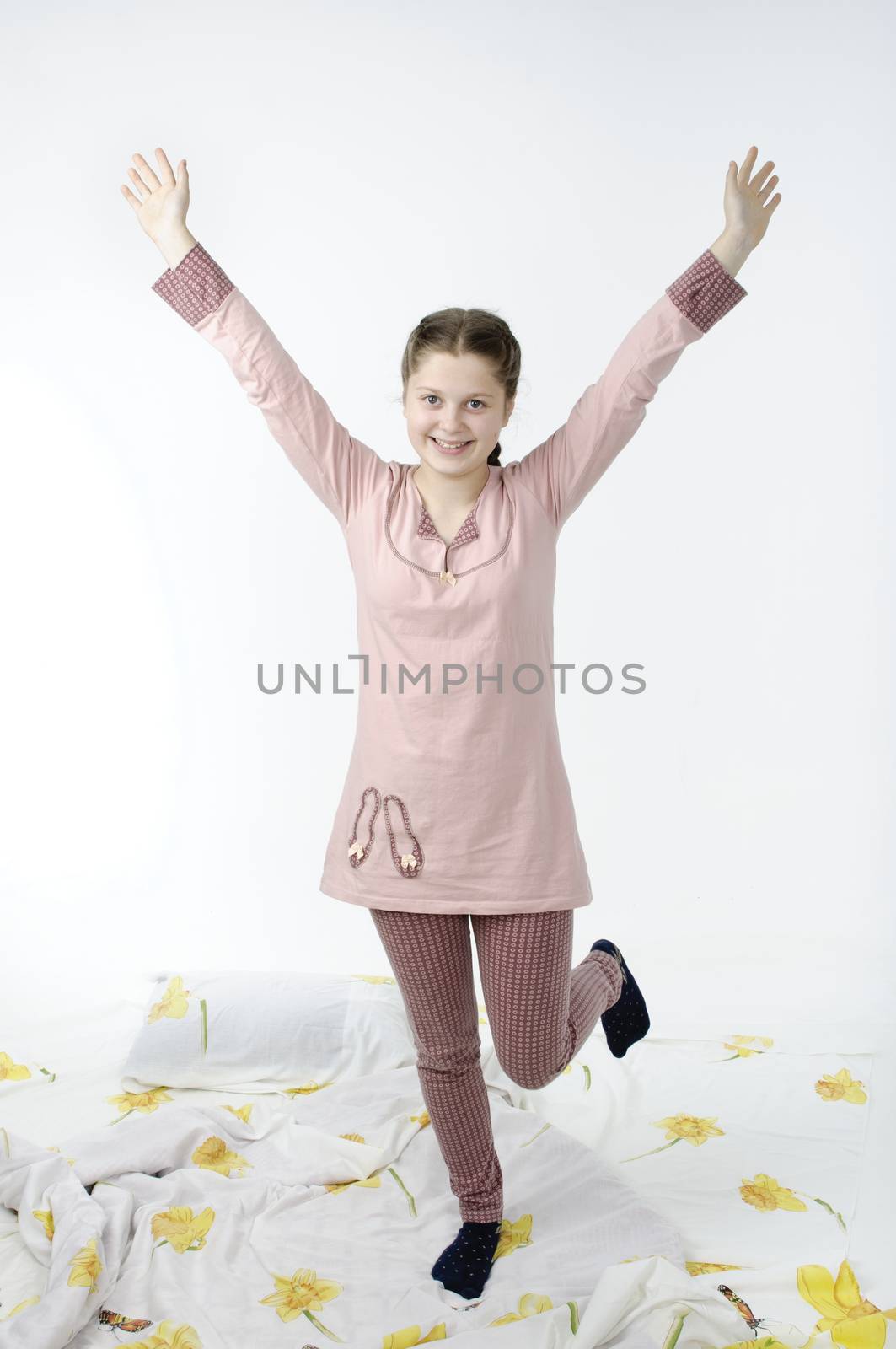 Little girl jumping on bed isolated on white