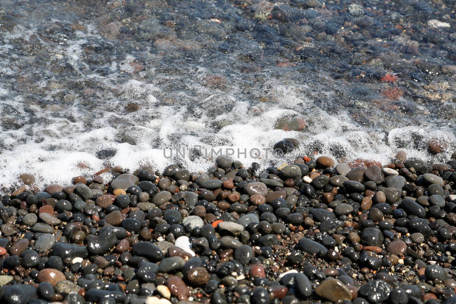 The Kamari beach with black volcanic stones at Santorini island, Greece
