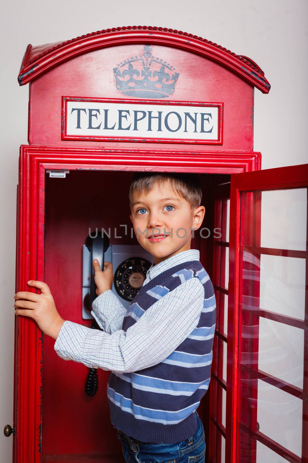 Cute little boy in the red telephone box