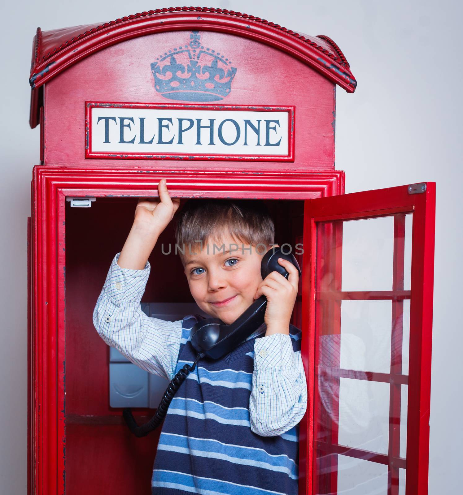 Cute little boy in the red telephone box