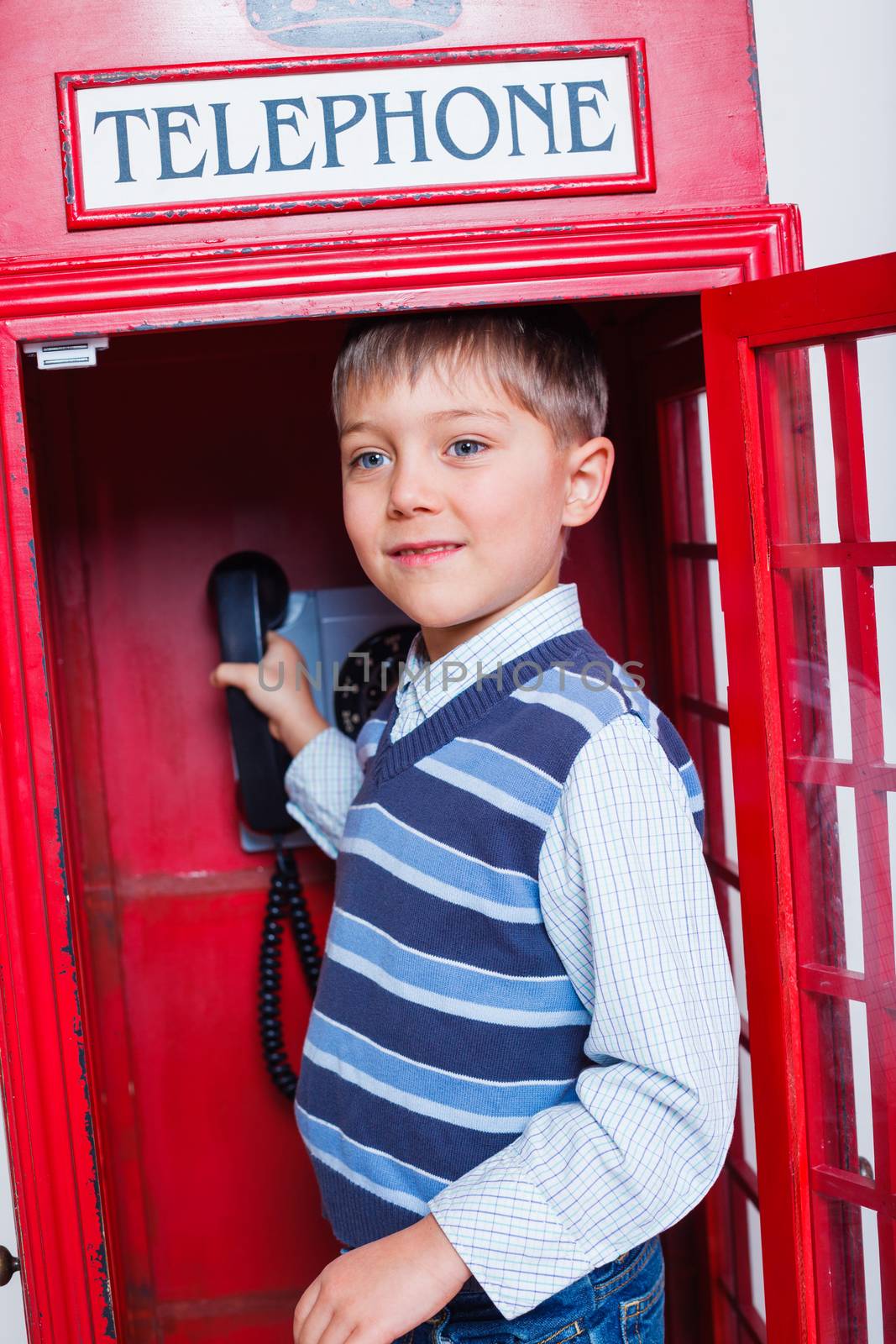 Cute little boy in the red telephone box