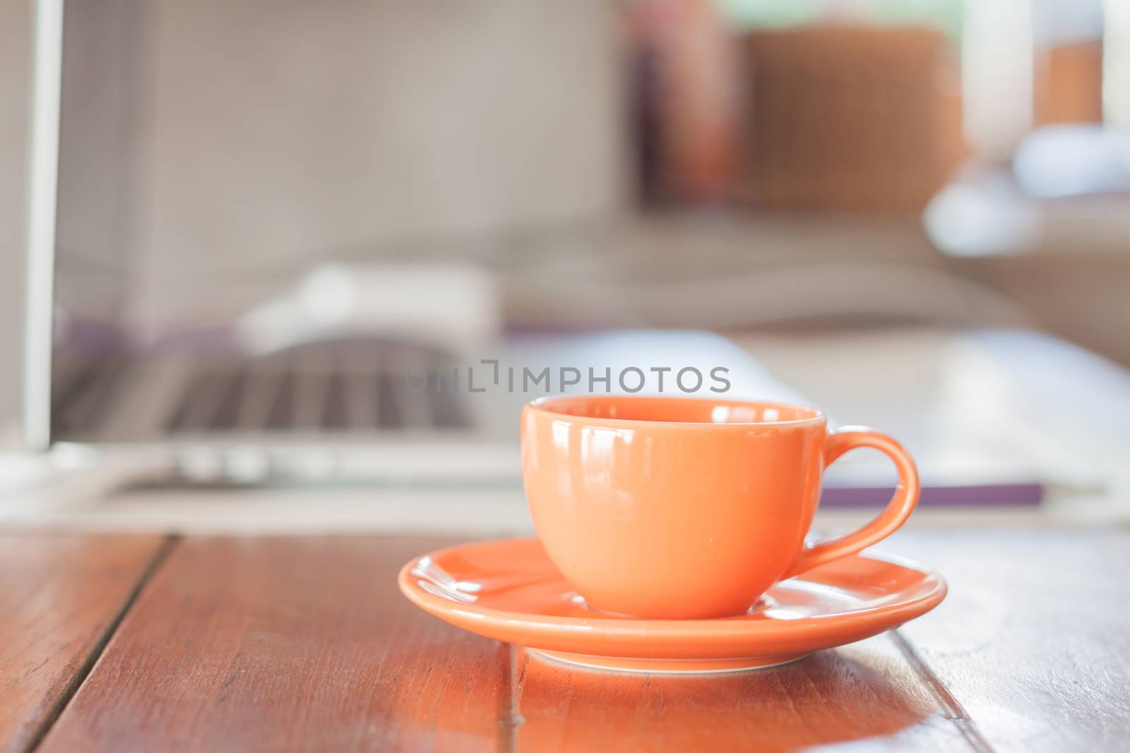 Mini orange coffee cup on work station, stock photo