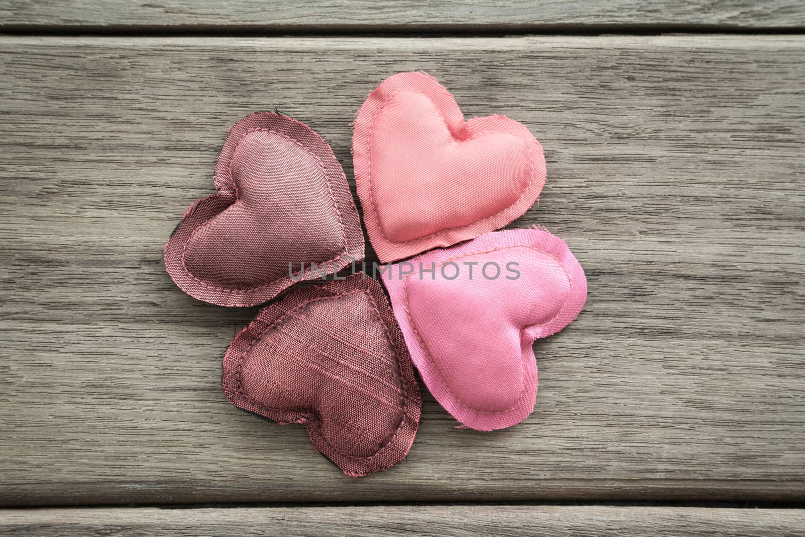 Group of pink tone hearts handmade crafts from silk cloth place on wood background, love and valentine's day symbol