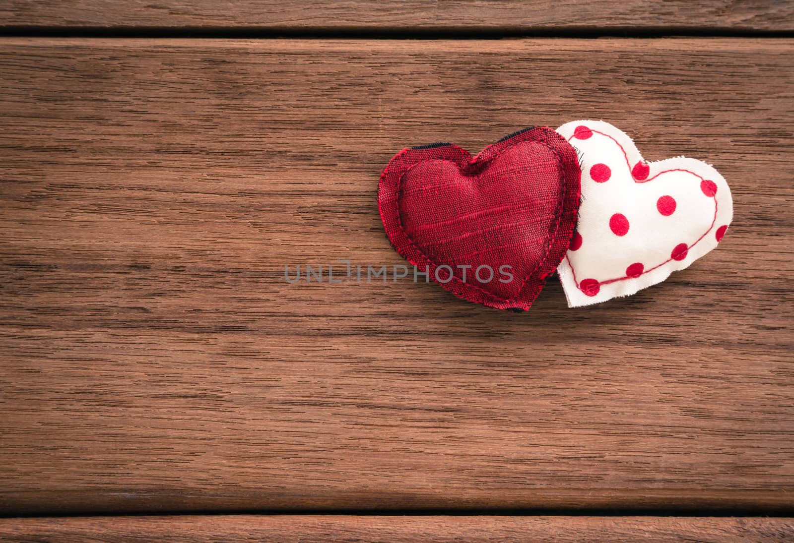 Red hearts handmade crafts from silk and cotton cloth place on wood texture, love and valentine's day symbol