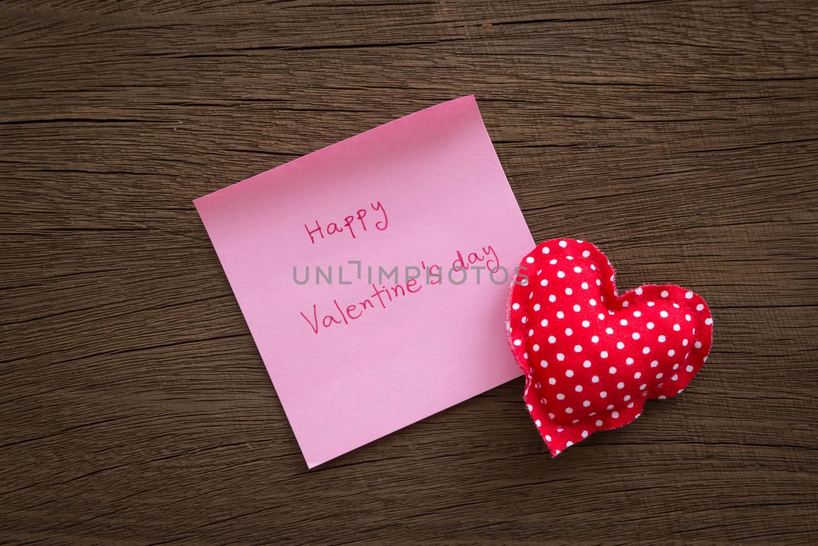 Red polka dot hearts with valentine note on wood texture by vinnstock