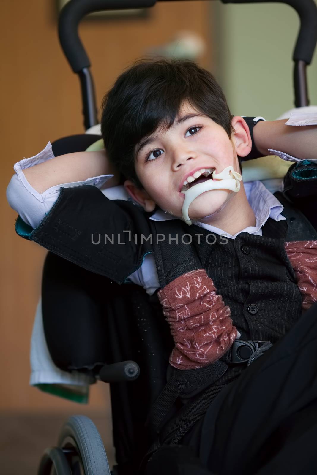 Handsome disabled eight year old biracial boy smiling and relaxi by jarenwicklund