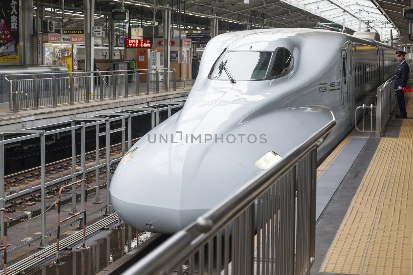 Shinkansen bullet train arriving at a train station by ymgerman