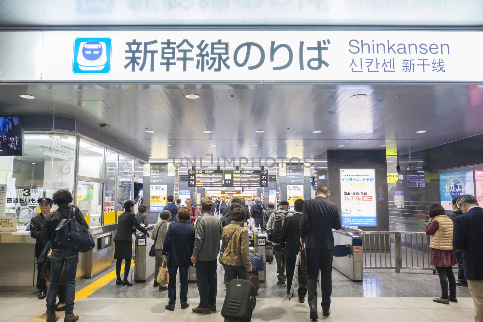 Commuters going through the tickets gates in a train station by ymgerman