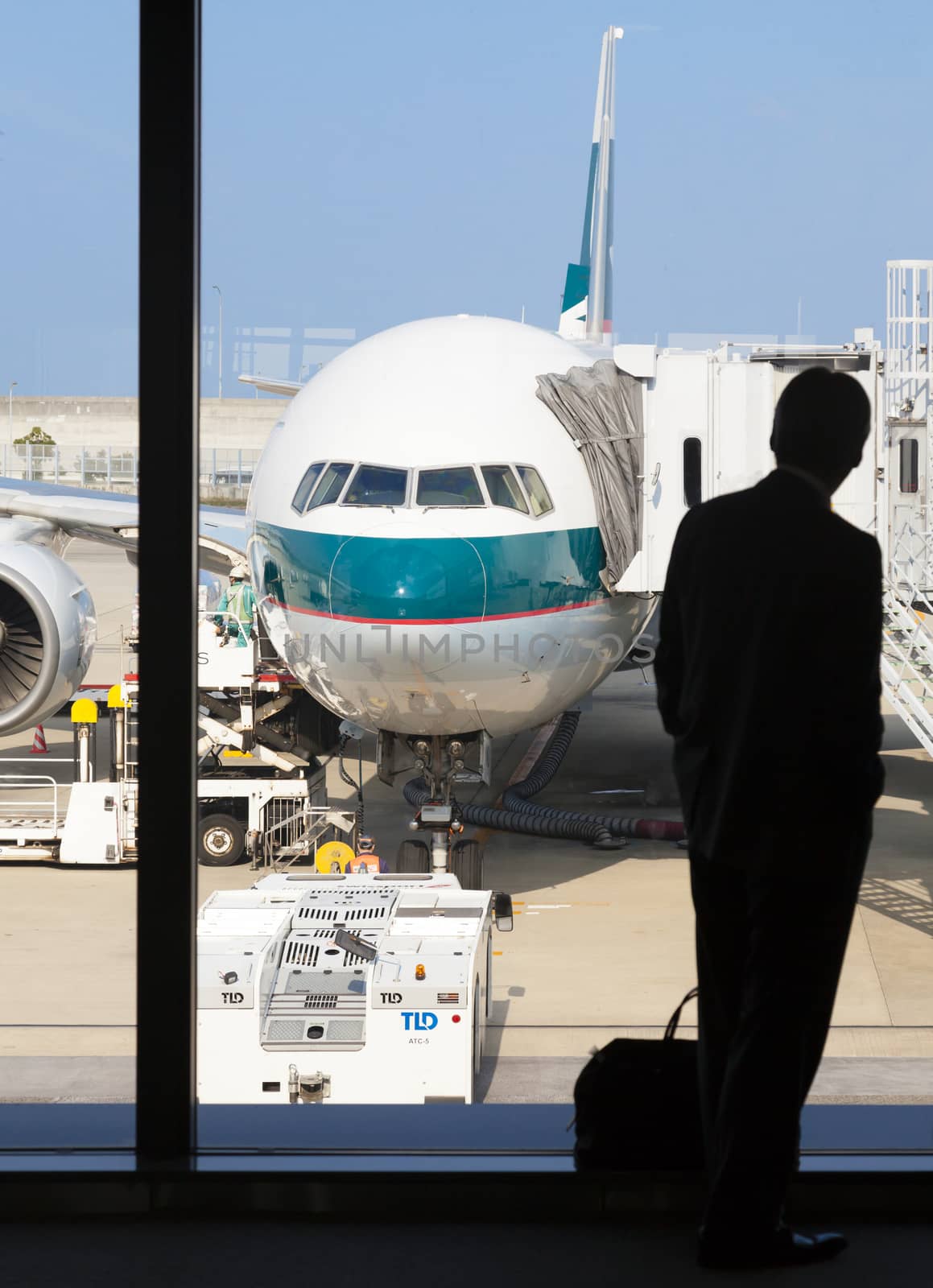 Osaka, Japan - Nov 7: Silhouette of a businessman waiting to board a Cathay Pacific passenger airplane in the Kansai International Airport in Osaka, Japan on Nov 7, 2014. Cathay Pacific is an international airline based in Hong Kong. It provides passenger and cargo services to 168 destinations in 42 countries worldwide.