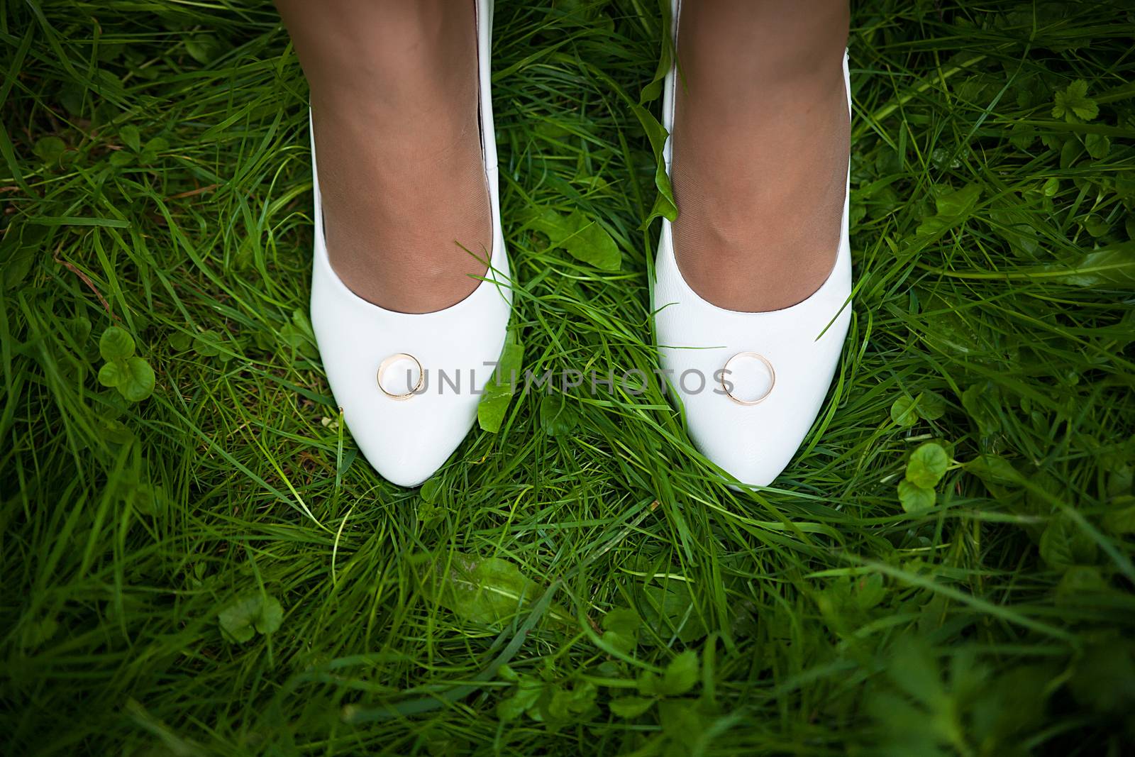 Wedding sandals and weddings rings on the grass